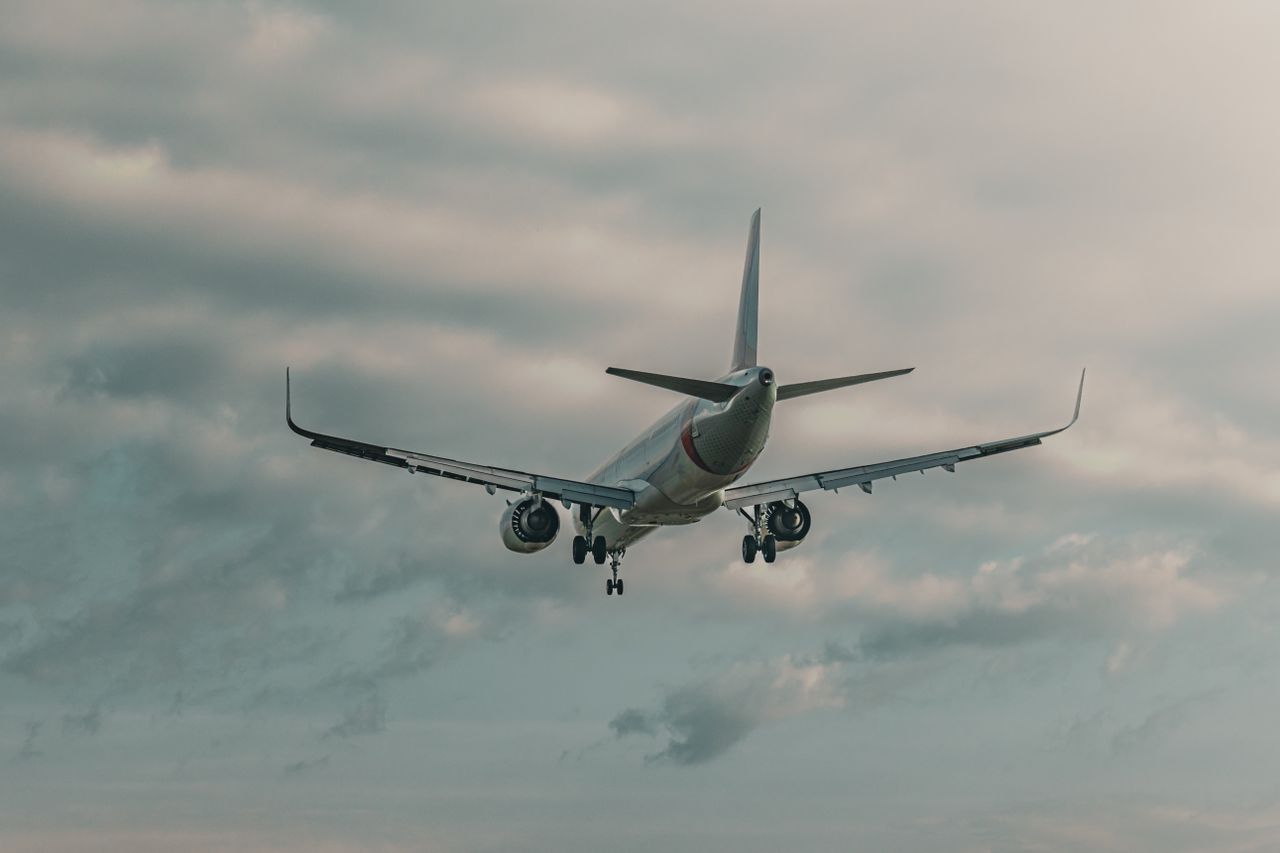 Airplane flying against a cloudy sky, capturing aviation dynamics.