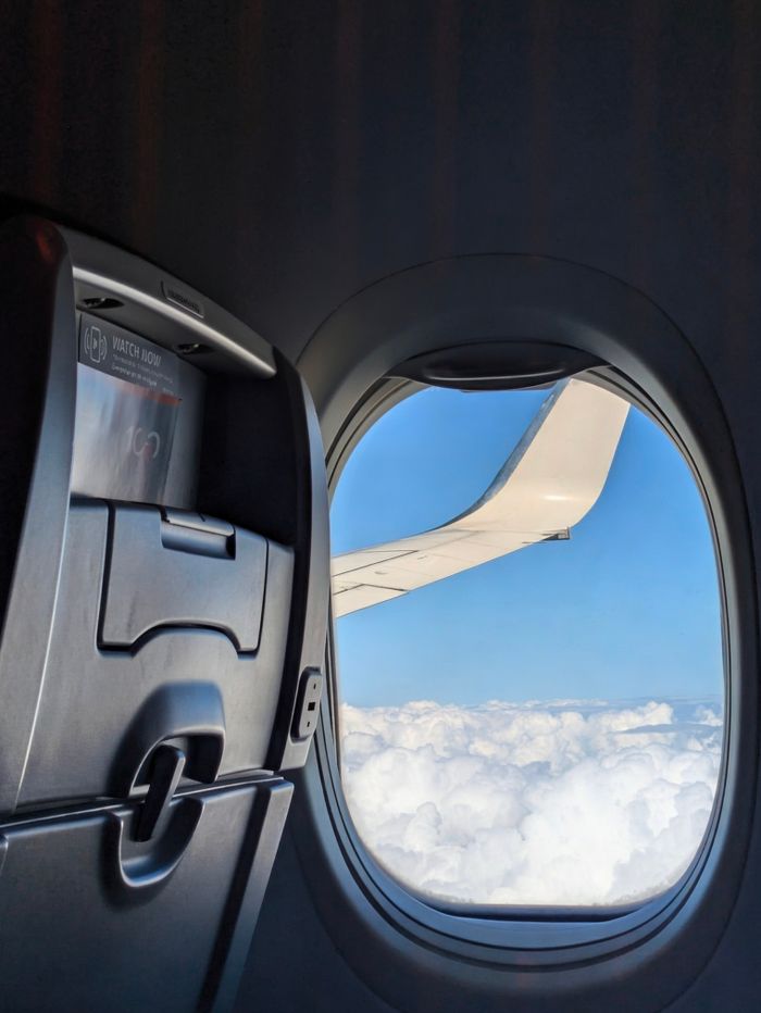 A stunning view of clouds and airplane wing from seat aboard a flight.